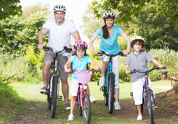 Family On Cycle Ride In Countryside Smiling To Camera